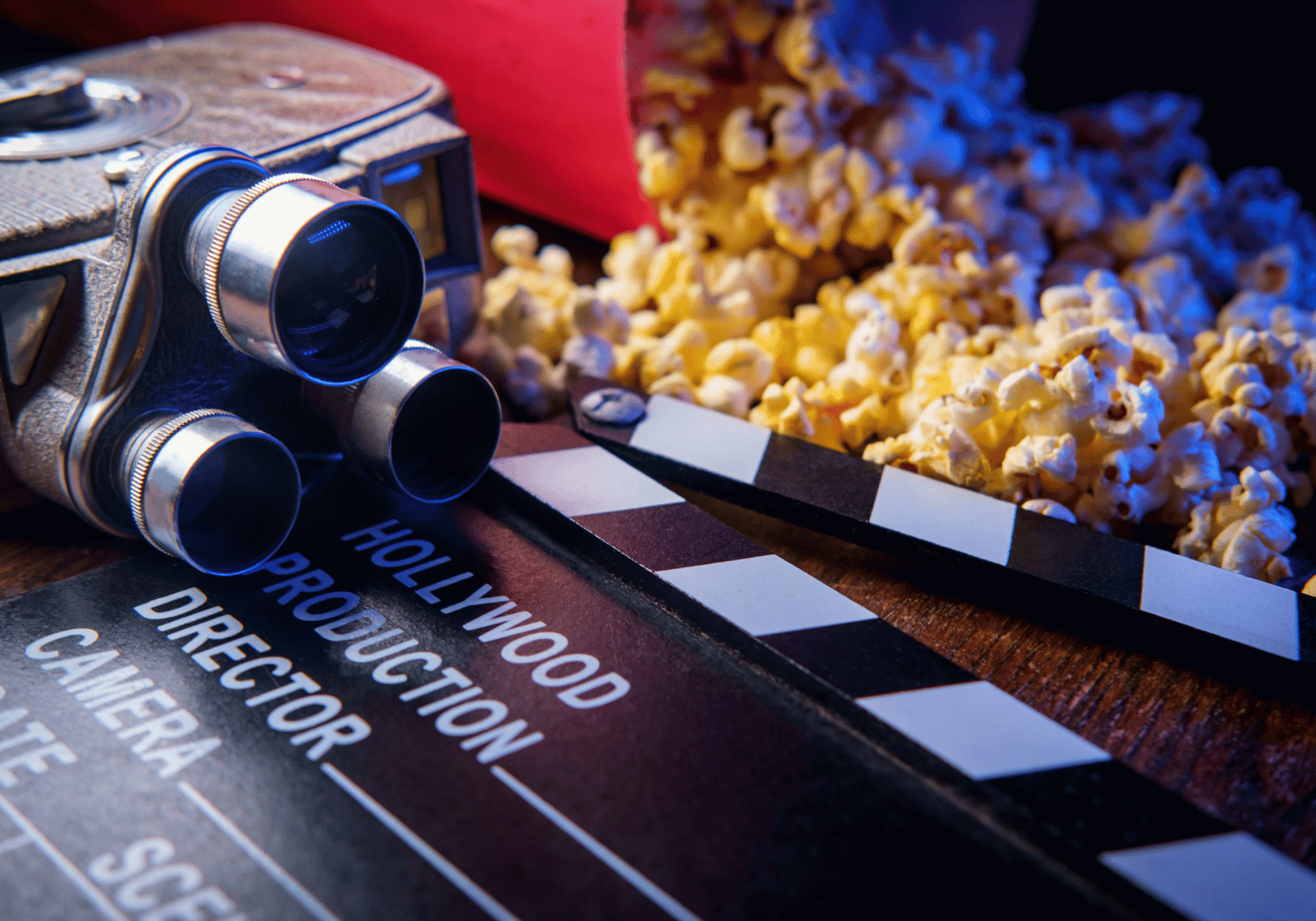 Vintage film camera with a clapboard and popcorn, evoking a movie night.